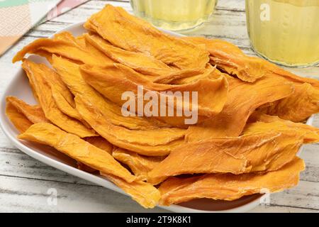Bowl with unsweetened dried mango chips without added sugar close up for a snack Stock Photo