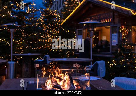 Meran, South Tyrol, Italy 02 December 2022 Fireplace and christmas trees with blurred lights  Stock Photo