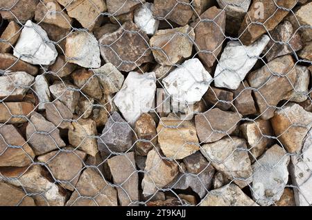 Stones in gabion, wire metal twisted mesh with stones, an element of landscape design. Stock Photo