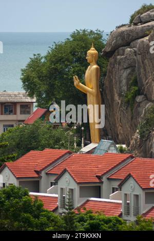 Entrance of Wat Khao Takiap in Hua Hin with a standing Buddha statue. Stock Photo