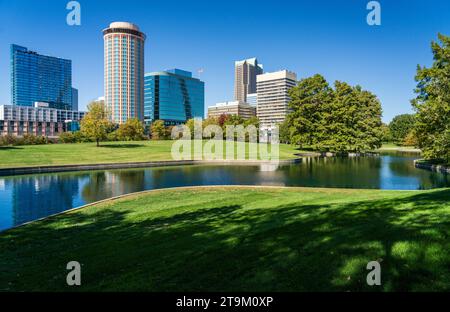 View across green planting of Gateway Arch park and across the lake to office buildings and hotels in downtown St Louis Missouri Stock Photo