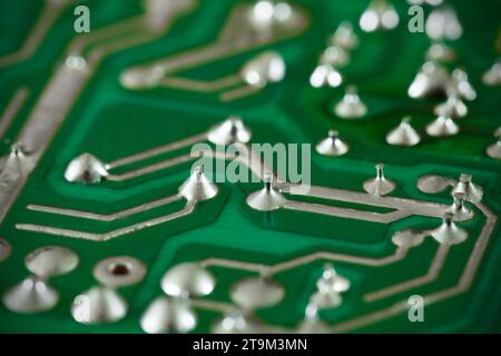 Printed circuit board green, electric, soldered legs of electrical components close-up macro view Stock Photo