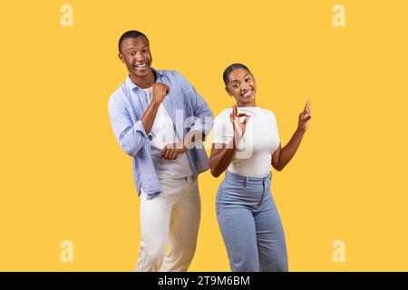 Happy black couple dancing and gesturing OK signs Stock Photo