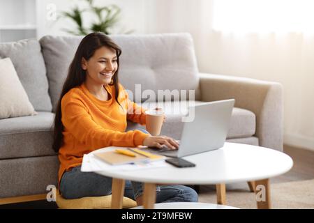 Positive young indian woman using laptop at home Stock Photo