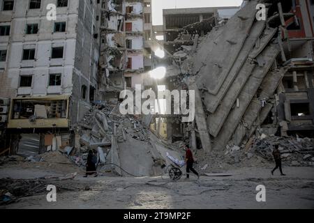 Gaza City, Palestinian Territories. 26th Nov, 2023. Palestinians walk through a destroyed neighbourhood in Gaza City, on the third day of the truce between Israel and Hamas. Credit: Omar Ishaq/dpa/Alamy Live News Stock Photo