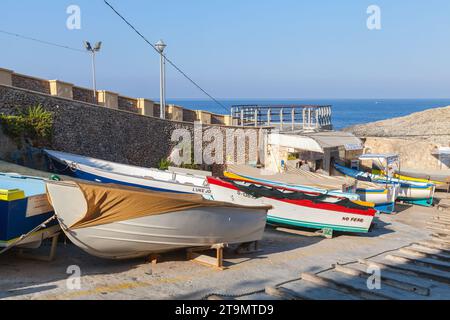 Blue Grotto, Malta - August 22, 2019: Street view with the way to the Blue Grotto Trips Departure Wharf. Wooden boats lay along the street on a sunny Stock Photo