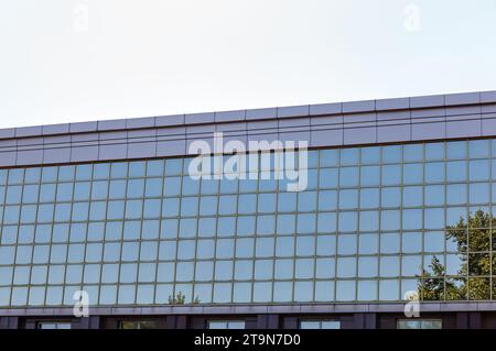 The glass mirrored surface of the facade of the office building. Exterior of modern building on a sunny day Stock Photo