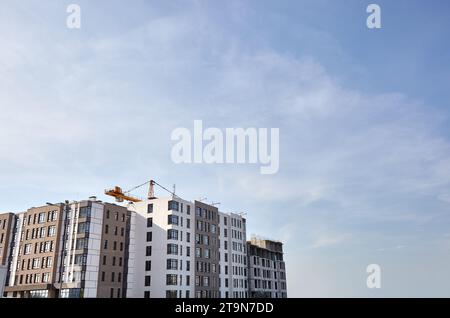 Fragment of tower crane, building a house. Concrete building under construction. Construction site Stock Photo