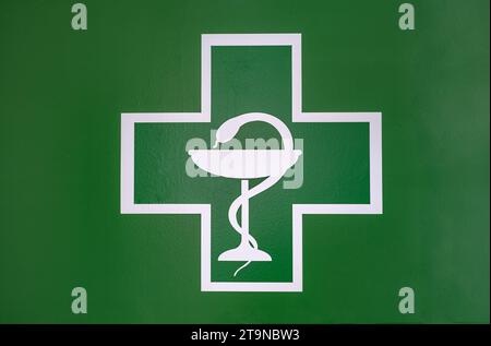 Medical Cross with the bowl of Hygeia. Modern Emblem of healthcare, medicine and pharmacy. Pharmacy symbol with snake and bowl Stock Photo