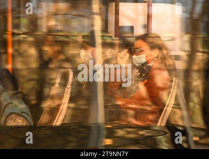 Belgrade, Serbia- March 18, 2022: People passengers riding in a city bus on the sunny day, with sunlight and city colors reflections on the window Stock Photo