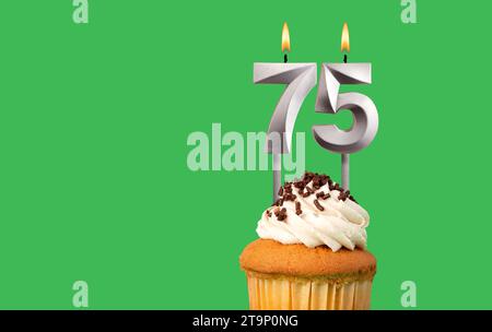 Birthday card with candle number 75 - Cupcake on green background Stock Photo