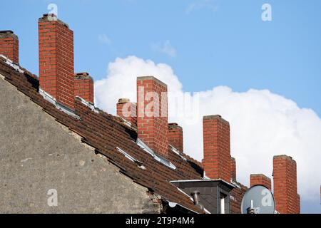 many brick chimneys on the roof of an old apartment building Stock Photo