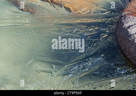 natural ice crystals on a high mountain lake shore grow from a granite rock Stock Photo