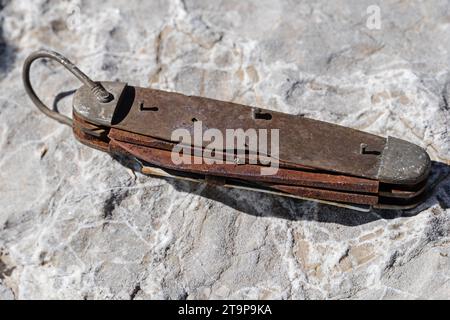 old broken rusty pocket knife sitting on a rock Stock Photo