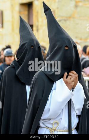 Penitents wearing Capirote hats during the Easter time Good Friday silent parade commemorating the Crucifixion and death of Jesus Christ, in Oaxaca city, Mexico Stock Photo