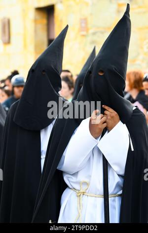 Penitents wearing Capirote hats during the Easter time Good Friday silent parade commemorating the Crucifixion and death of Jesus Christ, in Oaxaca city, Mexico Stock Photo