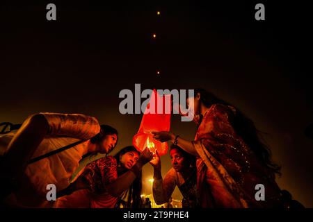 Varanasi, India. 26th Nov, 2023. A group of young people light a Sky Lantern during the Dev Deepavali Festival at Varanasi. Dev Deepavali/Diwali is the biggest festival of light celebration in Kartik Poornima (Mid-Autumn) where devotees decorate the river bank with millions of lamps during the festival. (Photo by Avishek Das/SOPA Images/Sipa USA) Credit: Sipa USA/Alamy Live News Stock Photo