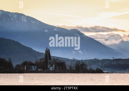 sunset over the mountains, with church and lake zurich in foreground Stock Photo