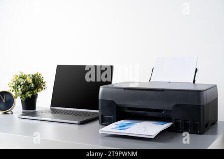 Printer and laptop on grey table in office Stock Photo