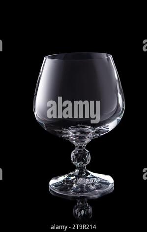 empty brendy glass isolated on black background Stock Photo