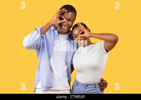 Happy black couple making fun hand gestures Stock Photo