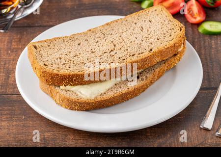 Cheddar toast on white porcelain plate on wooden table Stock Photo