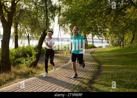 Older married couple enjoying jogging exercise during beautiful sunny summer day Stock Photo