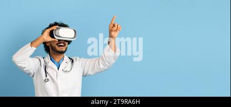 Indian doctor using wireless VR goggles, blue background, web-banner Stock Photo