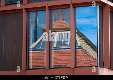 Tiled roof of old wharf warehouse reflected in modern windows, Wellington, North Island, New Zealand Stock Photo