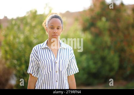 Serious black woman looking at you in a park Stock Photo