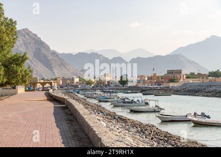 Boats moored at the end of the eastern Sea Canal with Khasab town behind, Musandam, Oman Stock Photo