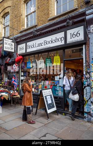 Brick Lane Bookshop in Brick Lane in London's East End. Customers entering Brick Lane Bookshop at 166 Brick Lane Shoreditch East London. Stock Photo