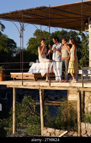 Friends having drinks on a deck in Carmelo, Uruguay. Stock Photo