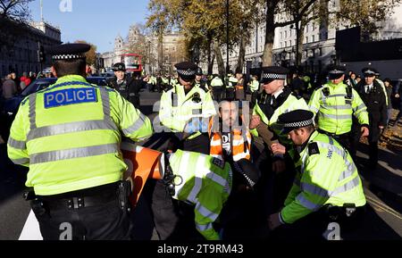 London, Whitehall, UK, 23rd November 2023, Just Stop Oil protesters are arrested by Metropolitan Police for public order offenses. Stock Photo