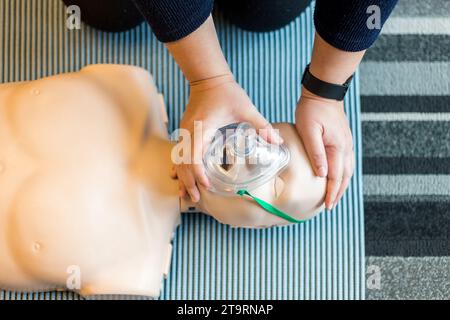 Woman performing CPR training dummy Stock Photo
