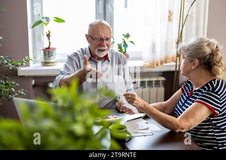 Senior couple discussing their home finances while sitting at the table Stock Photo