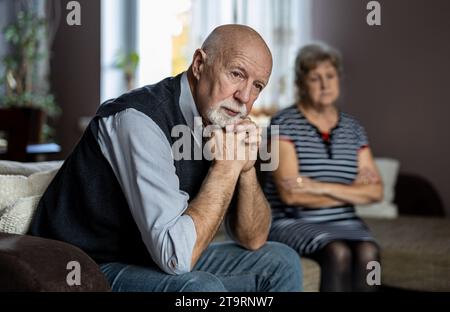Senior couple sitting on sofa at home having a relationship problems Stock Photo