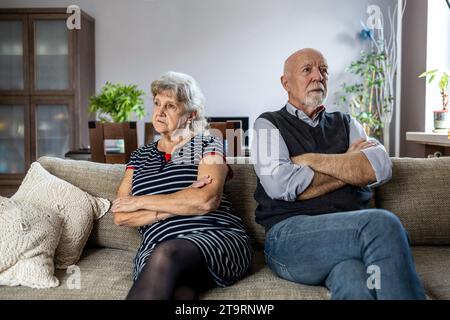 Senior couple sitting on sofa at home having a relationship problems Stock Photo