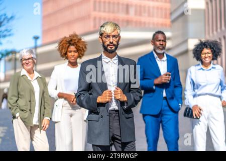 Portrait of young business man with the team of colleagues from diverse generations and ethnicities standing Stock Photo