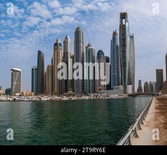 The skyscrapers of Dubai Marina, United Arab Emirates, seen from the sidewalk towards the sea. Stock Photo