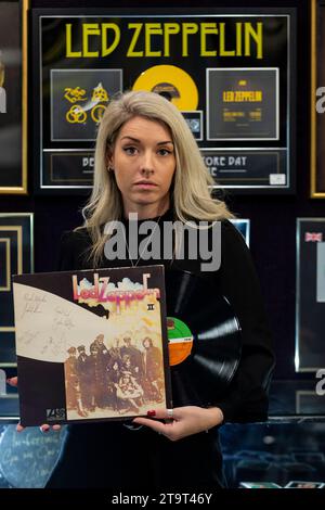 London, UK.  27 November 2023. A staff member with ‘An autographed copy of the album Led Zeppelin II’, early 70s reissue, the front cover signed and variously inscribed in black ballpoint by John Bonham, John Paul Jones, Robert Plant and Jimmy Page (Est. £20,000 - £30,000) at a preview of the Bonhams’ Rock, Pop & Film sale.  The sale takes place at Bonhams Knightsbridge galleries on 29 November.   Credit: Stephen Chung / Alamy Live News Stock Photo