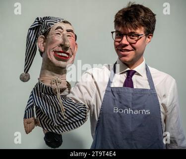 London, UK.  27 November 2023.  A technician with a ‘Hand puppet of (Prince) Charles in nightwear’ from Spitting Image, circa 1980s, (Est. £800 - £1,200) at a preview of the Bonhams’ Rock, Pop & Film sale.  The sale takes place at Bonhams Knightsbridge galleries on 29 November.   Credit: Stephen Chung / Alamy Live News Stock Photo