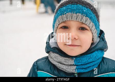 cute little boy, kid in winter clothes walking under the snow Stock Photo