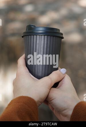 Woman Holding a Paper Takeaway Coffee Cup in Hand. Stock Photo