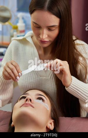 master preparing glue cotton tape under eye. Eyelash extension procedure Stock Photo