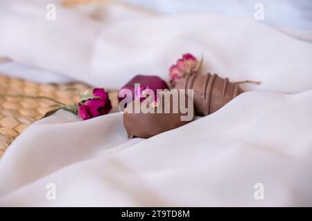 Chocolate Pieces with Elegant Flowers and Roses on Pink and White Background. Romantic Concept with Mock-Up Space for Customization. Ideas for Valenti Stock Photo