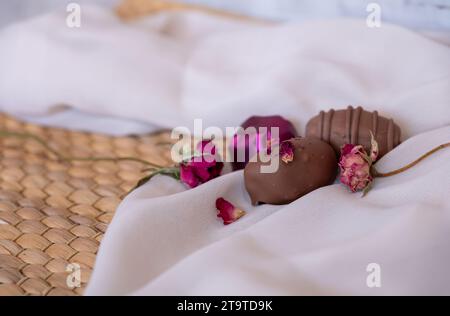 Chocolate Pieces with Elegant Flowers and Roses on Pink and White Background. Romantic Concept with Mock-Up Space for Customization. Ideas for Valenti Stock Photo