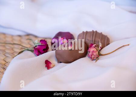 Chocolate Pieces with Elegant Flowers and Roses on Pink and White Background. Romantic Concept with Mock-Up Space for Customization. Ideas for Valenti Stock Photo