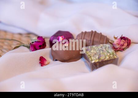 Chocolate Pieces with Elegant Flowers and Roses on Pink and White Background. Romantic Concept with Mock-Up Space for Customization. Ideas for Valenti Stock Photo