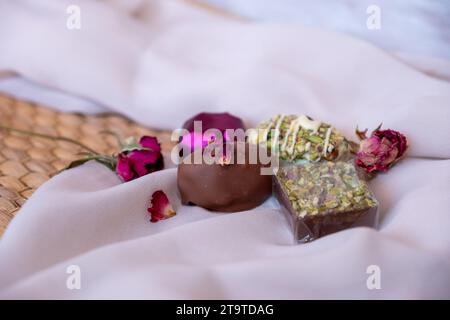 Chocolate Pieces with Elegant Flowers and Roses on Pink and White Background. Romantic Concept with Mock-Up Space for Customization. Ideas for Valenti Stock Photo